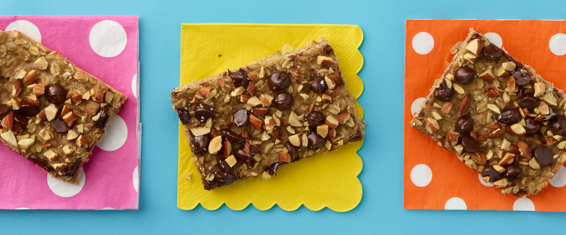 Three 5-Ingredient Peanut Butter Bars on a pink, yellow and orange napkin with a teal background.