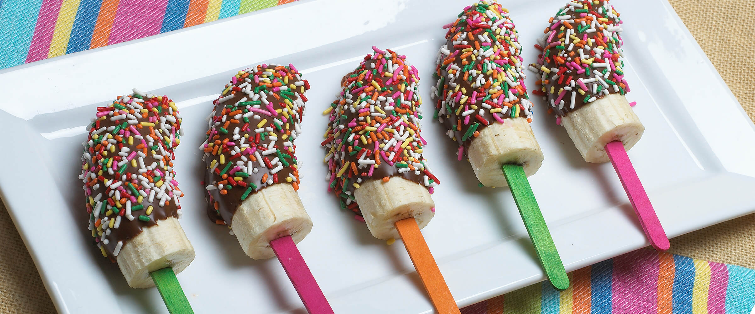 Bananas dipped in chocolate and colorful sprinkles