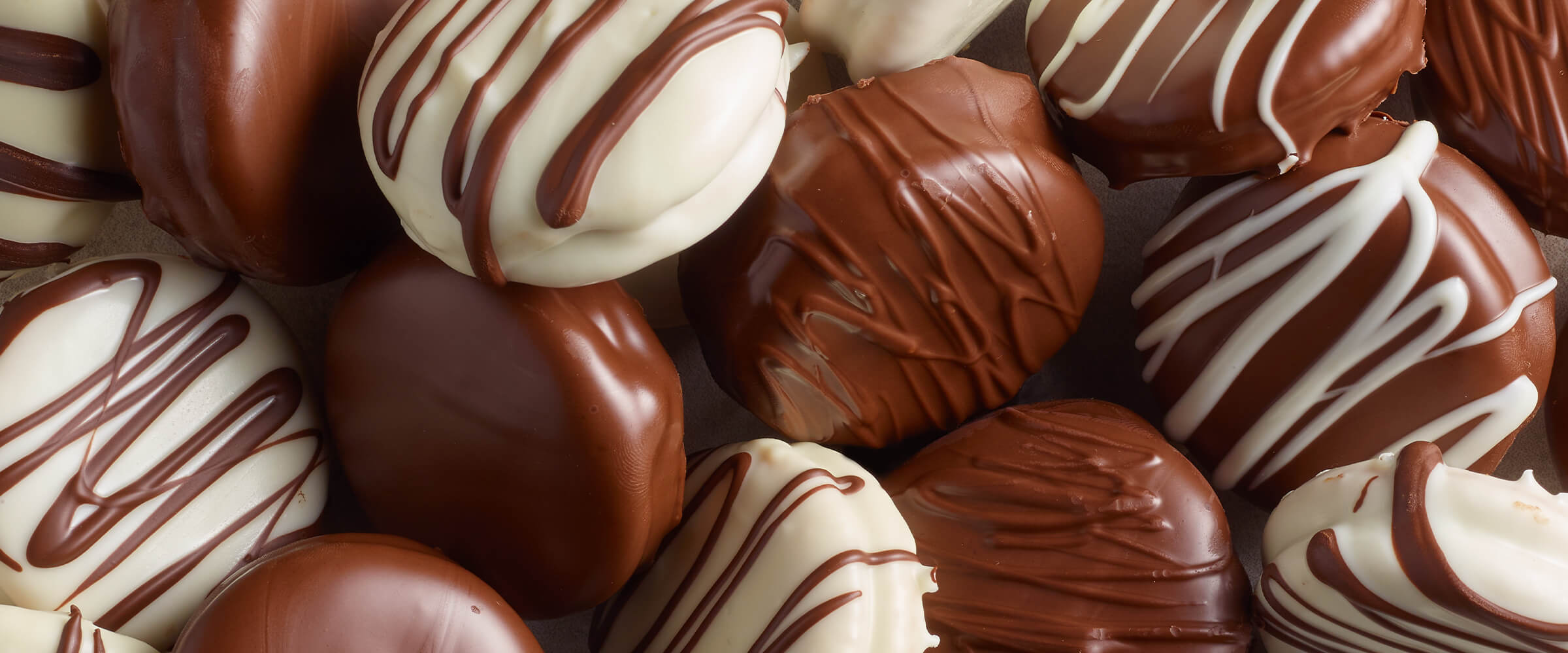 Chocolate covered peanut butter cracker sandwiches laying next to each other.