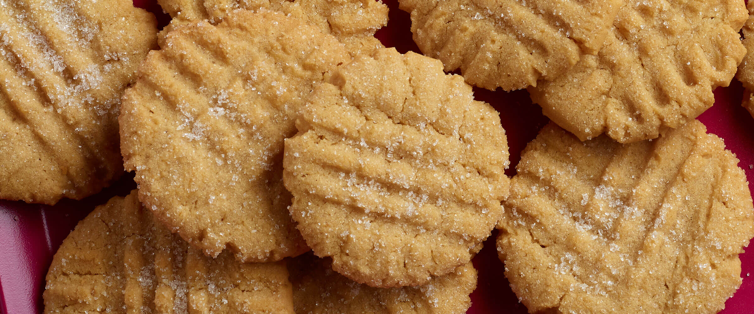 Peanut Butter Cookies with visual sugar granules on a pink plate
