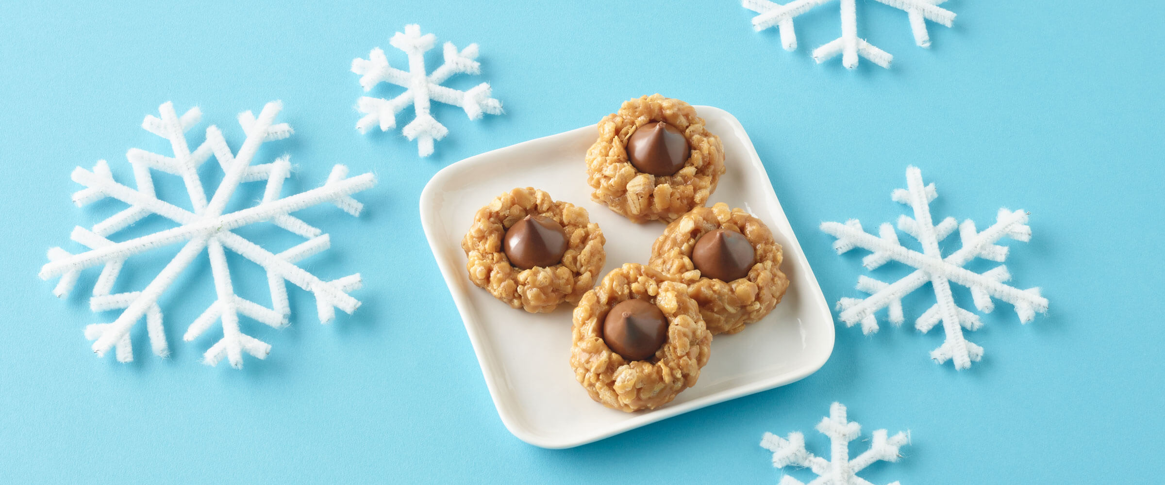 No Bake Peanut Butter Chocolate Drop Cookies on a square plate surrounded by snow flake decorations