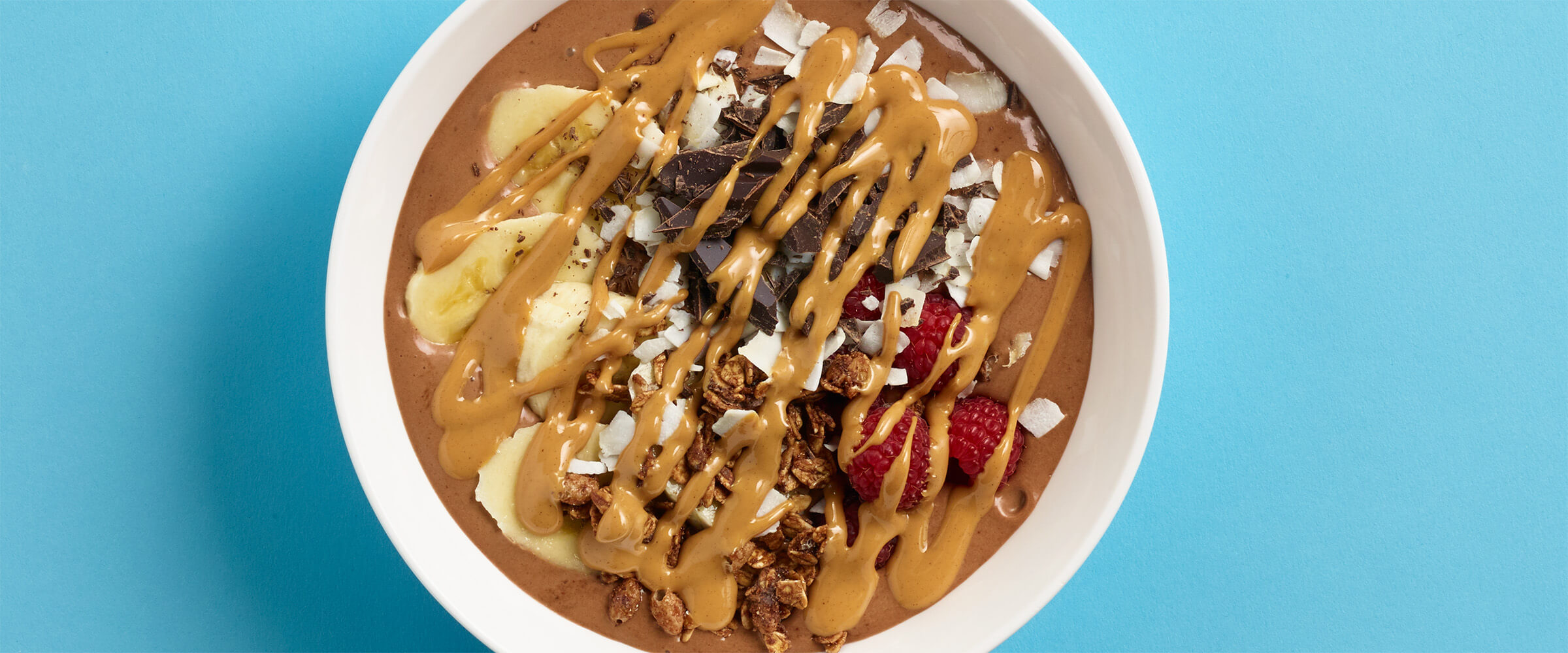 Overhead view of a smoothie bowl topped with a drizzle of peanut butter