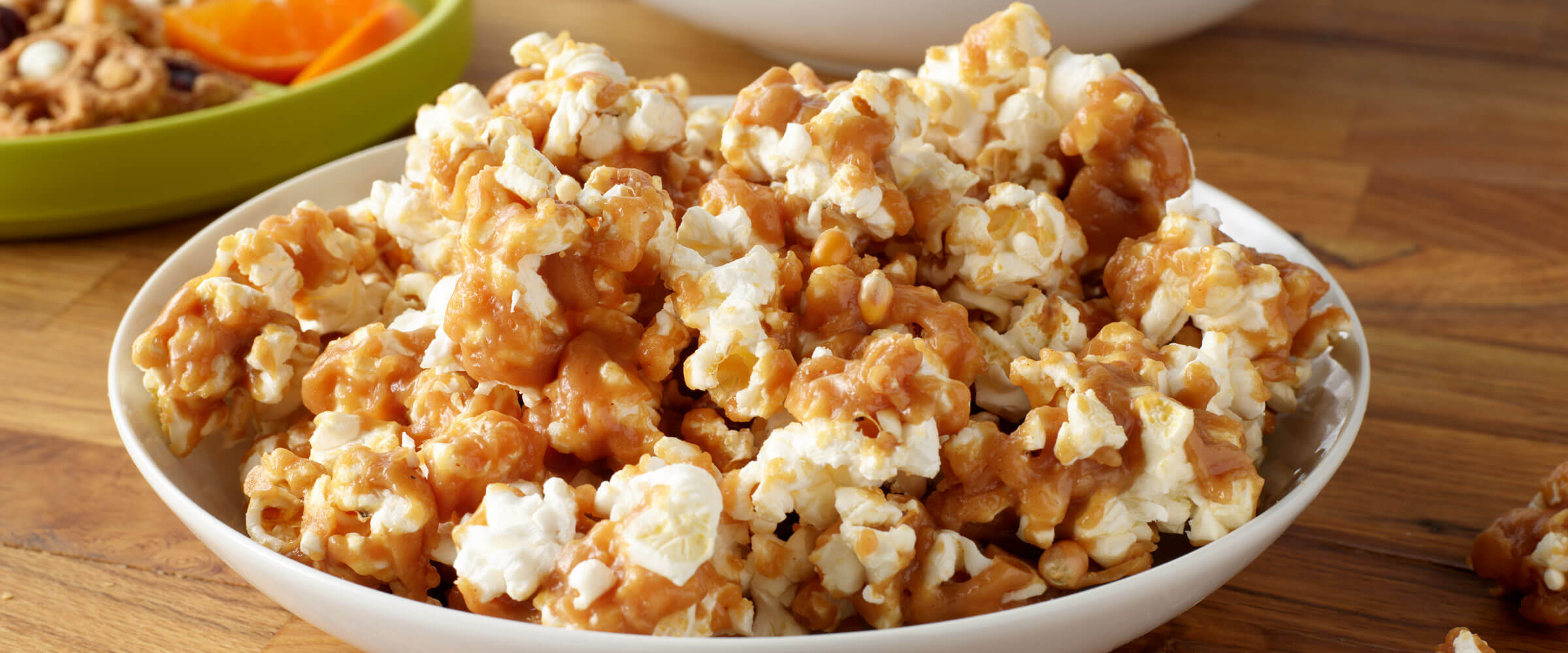 Peanut Butter Popcorn in a white bowl on a wooden table
