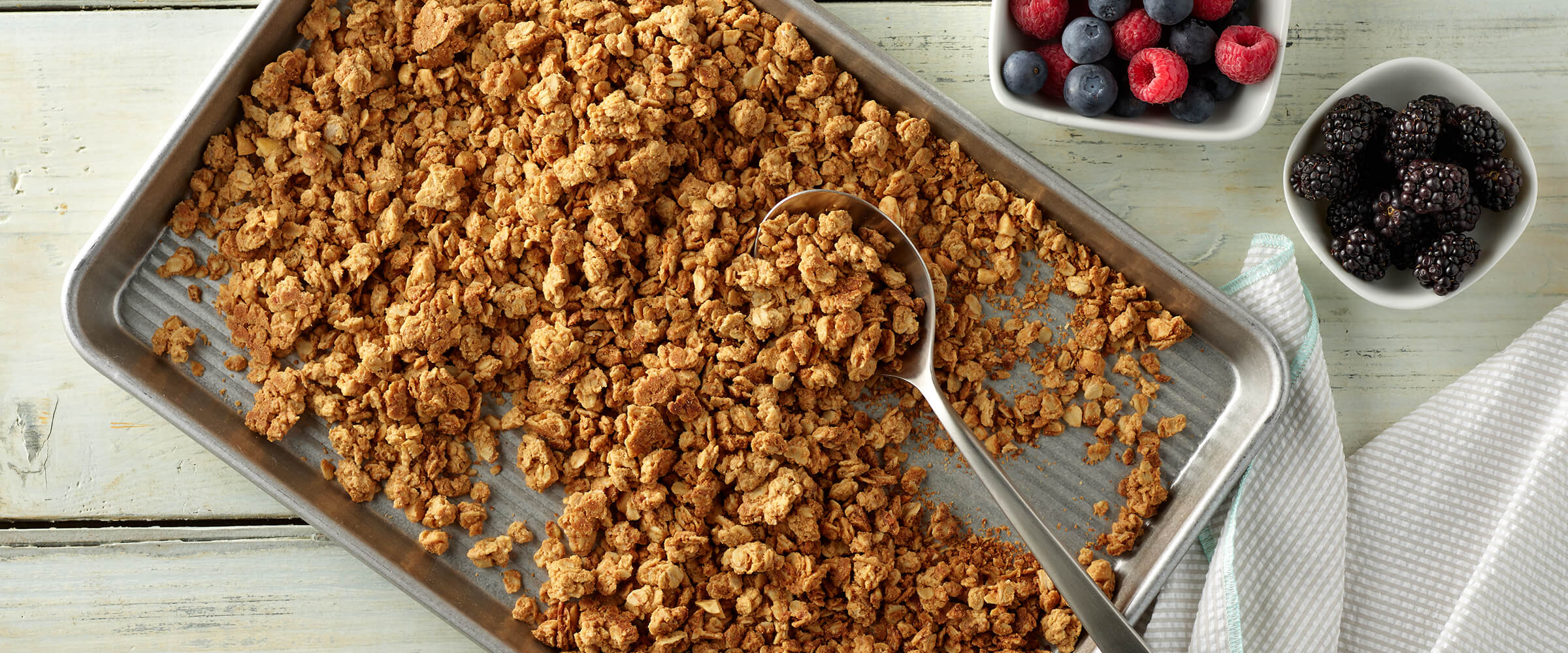 Peanut butter granola on a silver baking sheet.