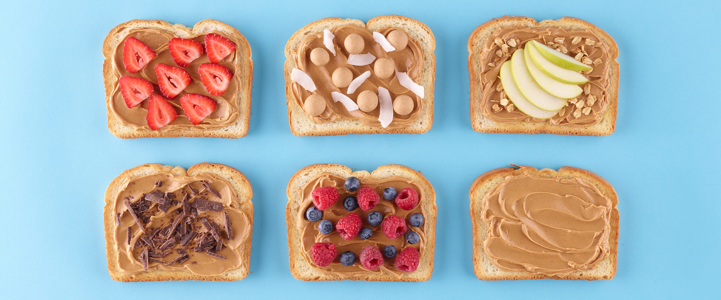 Six pieces of toast on a teal background with peanut butter and various toppings on them.