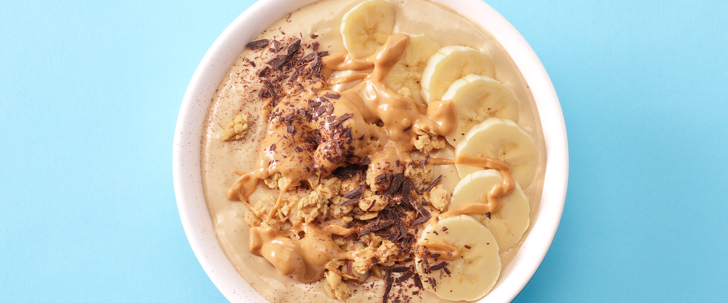 Peanut butter banana smoothie bowl with bananas, peanut butter and shaved chocolate.